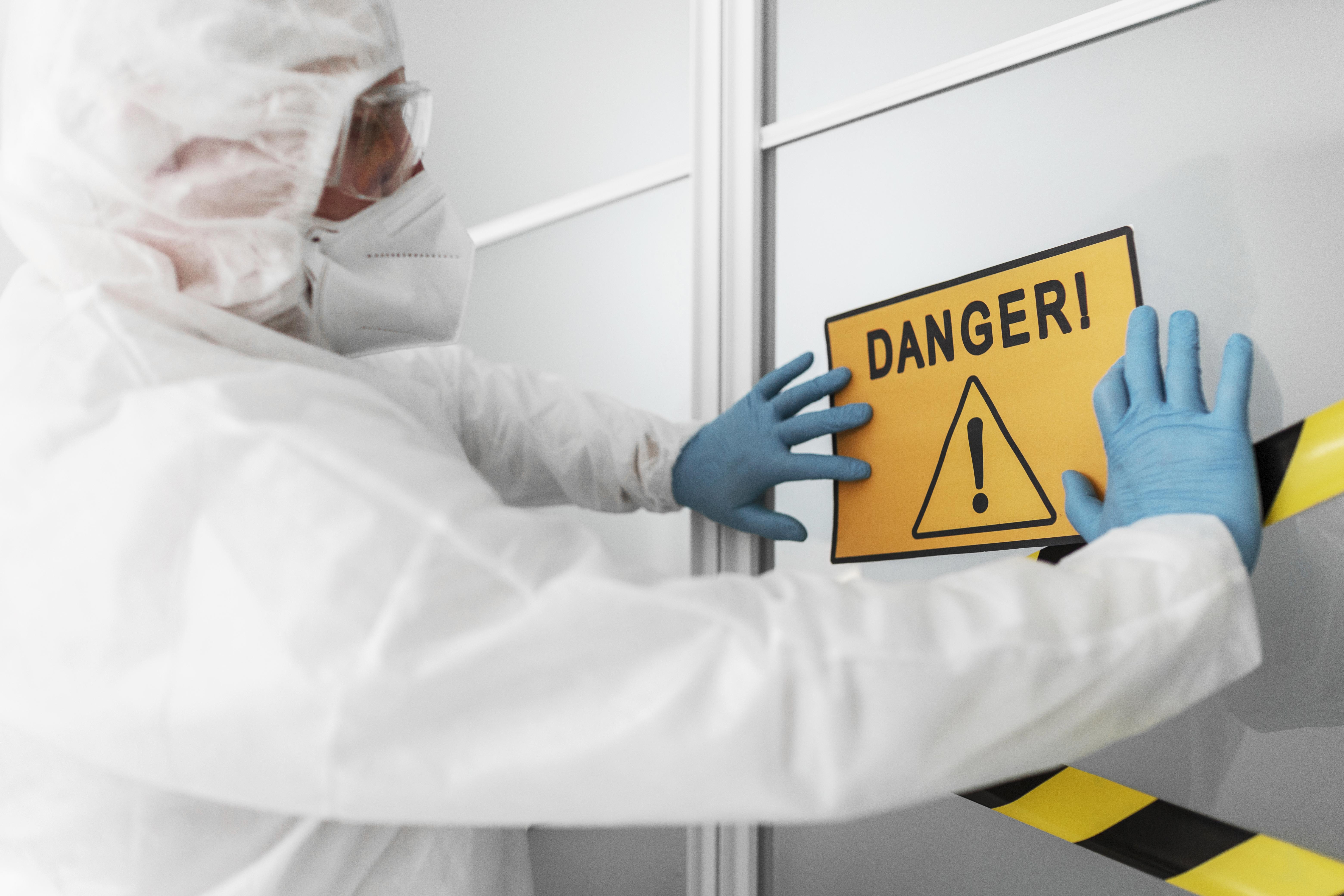 Dangerous goods -- man holding danger sign